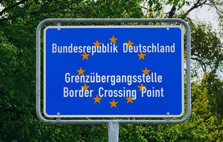 Grenzübergang zur Bundesrepublik Deutschland – lohnbuchhalterische Relevanz bei EU-Entsendungen und Auslandsbeschäftigung Hinweisschild „Bundesrepublik Deutschland – Grenzübergangsstelle / Border Crossing Point“ vor Bäumen – symbolisch für grenzüberschreitende Beschäftigung in der Lohnbuchhaltung