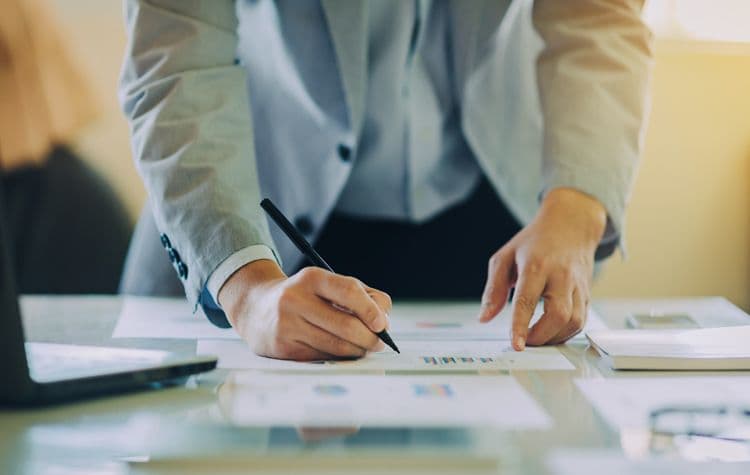 Lohnabrechnung prüfen und dokumentieren: Pflichtaufgaben im Payroll-Prozess Person in Businesskleidung prüft und unterschreibt ein Dokument mit Abrechnungsdaten