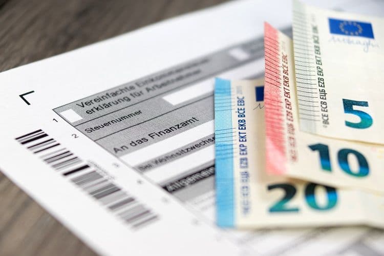 Lohnbuchhaltung und Steuerdokument – Abgabe an das Finanzamt mit Bezug zur Arbeitnehmerversteuerung Formular zur vereinfachten Steuererklärung für Arbeitnehmer mit Euro-Geldscheinen – symbolisiert steuerliche Aspekte der Lohnbuchhaltung