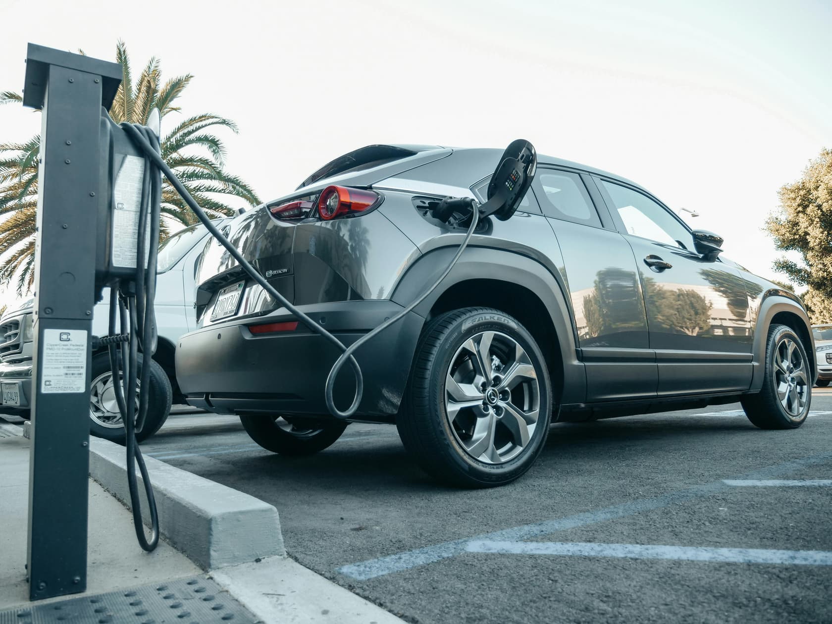 Ein Elektroauto wird an einer Ladestation auf einem Parkplatz aufgeladen - Elektro-Dienstwagen